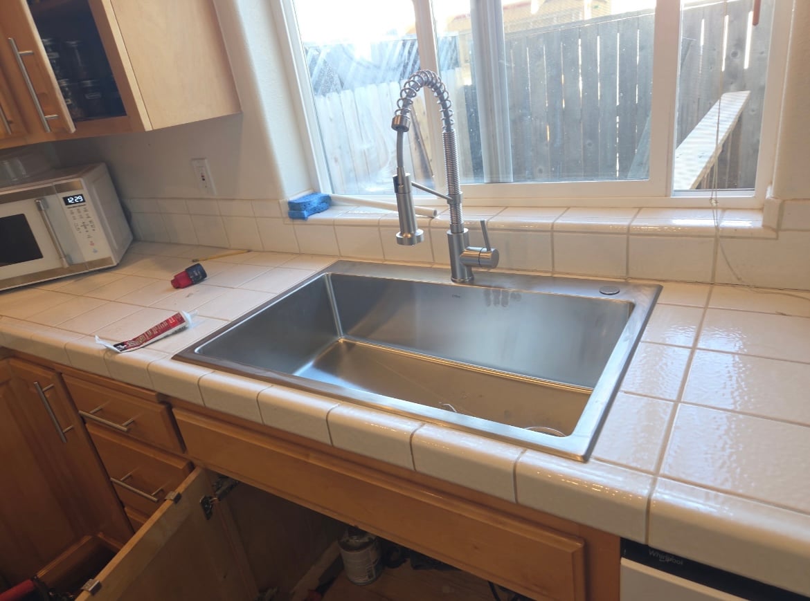 Completed stainless-steel kitchen sink and faucet installation by Table Rock Plumbing Solutions